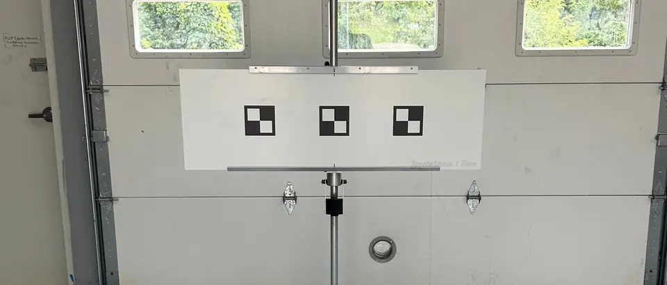 A calibration target with three checkered squares on a stand in the Impex service bay