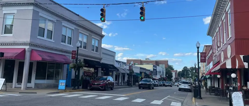 Salem Street in downtown Apex, NC, with shopfronts under a bright blue sky