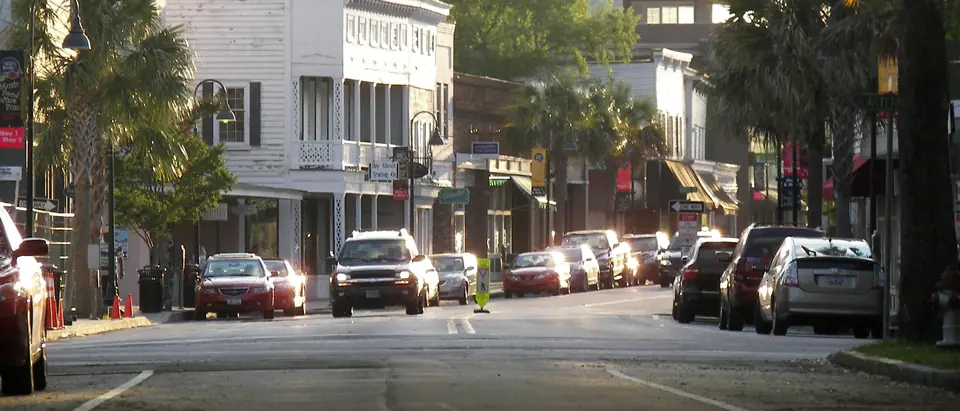 Bay Street in downtown Beaufort, SC, with palm trees, white storefronts and parked cars