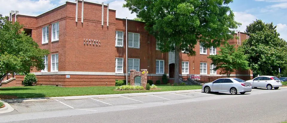 The red-brick Bessemer City Central School under a shade tree in Bessemer City, NC