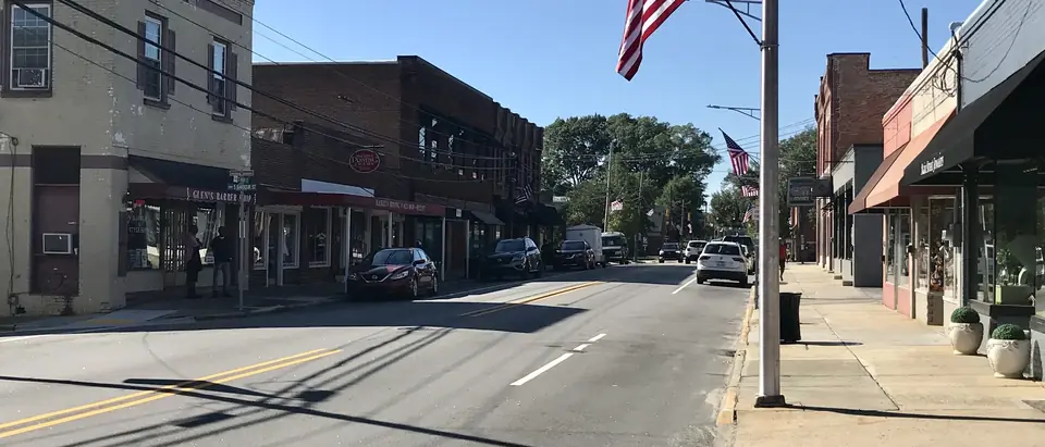 East Main Street in downtown Clayton, NC, with brick shops and an American flag