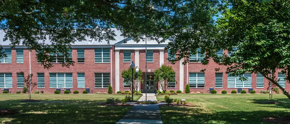 The red-brick Enfield Graded School framed by shade trees on a sunny day in Enfield, NC