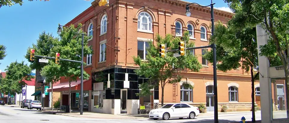 A red-brick corner building on North Limestone Street in downtown Gaffney, SC, under a blue sky