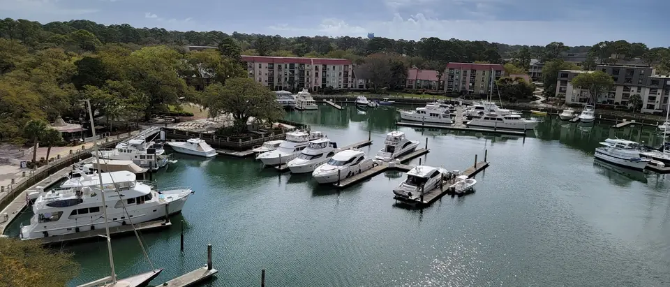 Yachts moored in the Harbour Town marina ringed by trees and villas on Hilton Head Island, SC