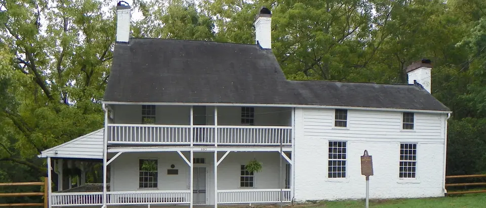 The historic white Mendenhall Plantation house beside Main Street in Jamestown, NC