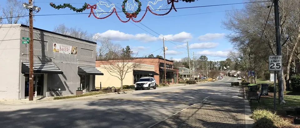 First Avenue in old downtown Knightdale, NC, with shops and a holiday garland over the street