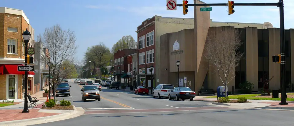 Main Street in downtown Lenoir, NC, with shops, street lamps and the Blue Ridge foothills beyond