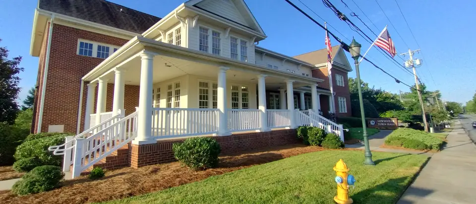The Lewisville Town Hall with its white porch and columns beside Shallowford Road in Lewisville, NC