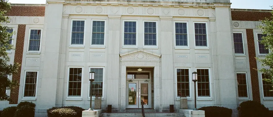 The white stone Lexington County Courthouse with its front steps and shrubs in Lexington, SC