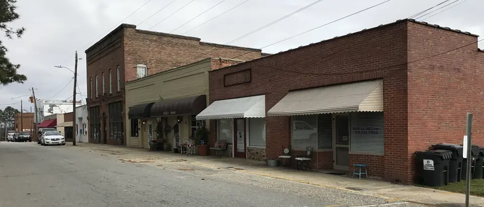 A row of brick storefronts with awnings on Main Street in downtown Lillington, NC