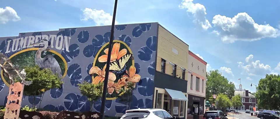 North Elm Street in downtown Lumberton, NC, with a colourful Lumberton mural under a blue sky