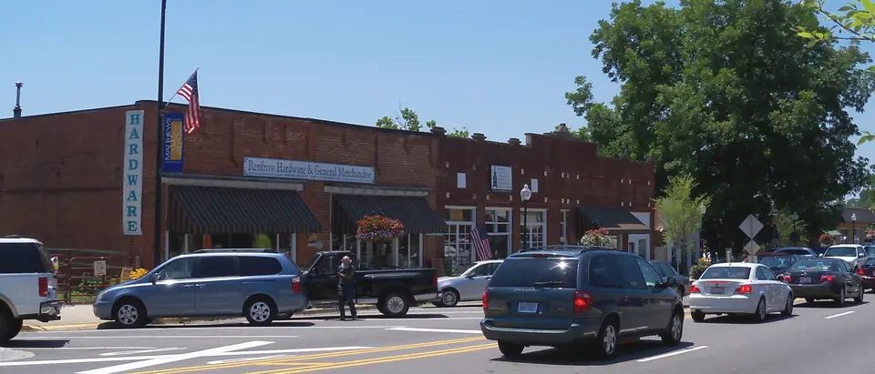 Trade Street in downtown Matthews, NC, with historic brick shops under a blue sky