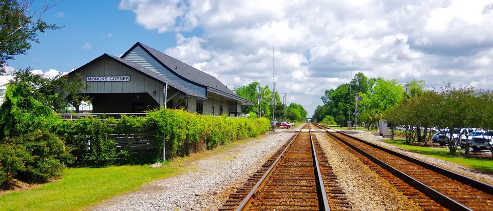 The old railroad depot beside the tracks in Moncks Corner, SC, under a blue summer sky