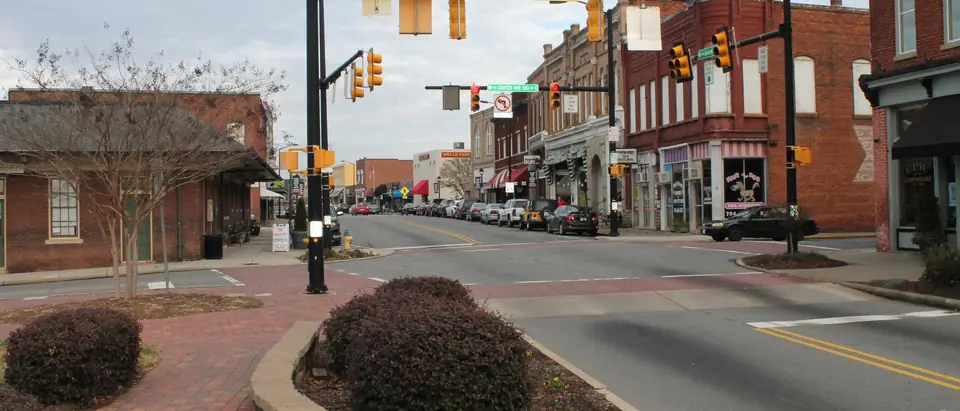 Main Street in downtown Mooresville, NC, with red-brick shops and the old train depot
