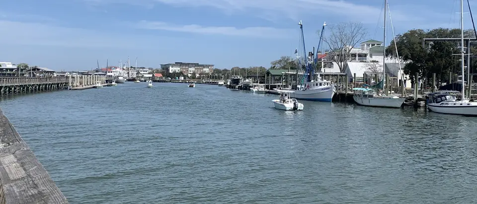 Boats and docks along Shem Creek in Mount Pleasant, SC, under a blue sky