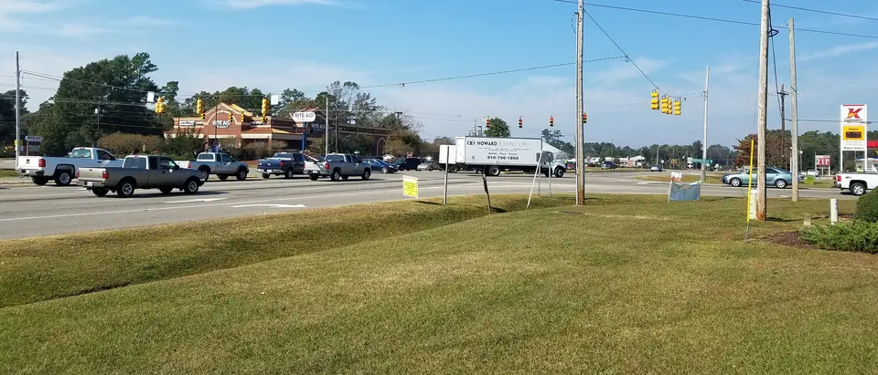 The main crossroads of Murraysville, NC, with shops and traffic lights under a blue sky