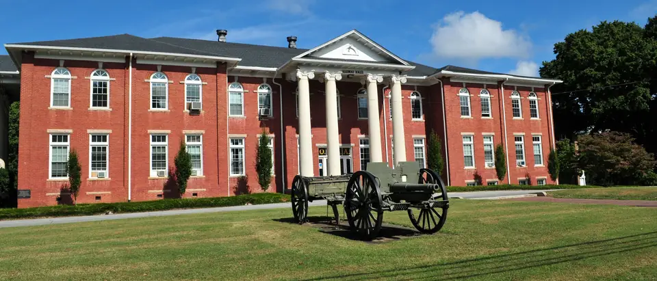 The red-brick, white-columned main hall of Oak Ridge Military Academy under a blue sky in Oak Ridge, NC