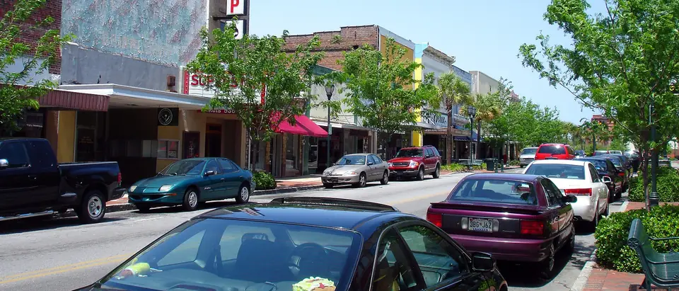 Russell Street in downtown Orangeburg, SC, with shops, street trees and parked cars