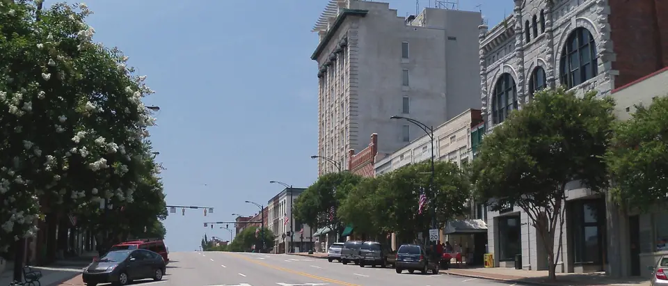 Main Street in downtown Salisbury, NC, with historic tall buildings and crape myrtles in bloom