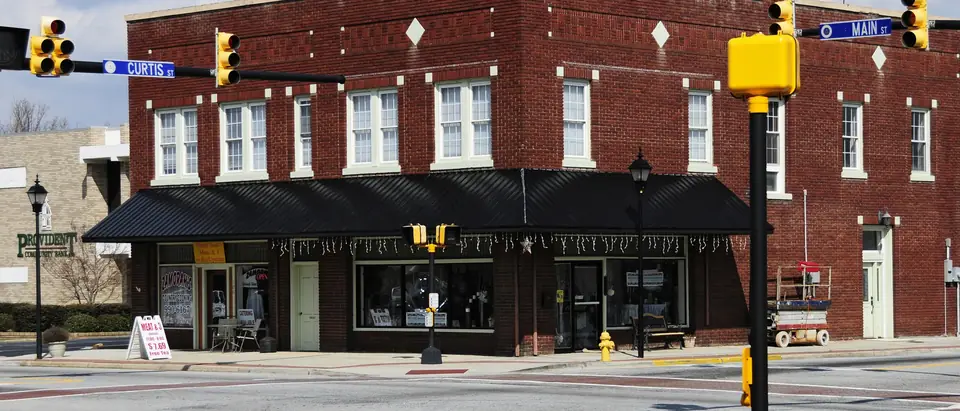 A red-brick corner building on Main Street at Curtis Street in downtown Simpsonville, SC