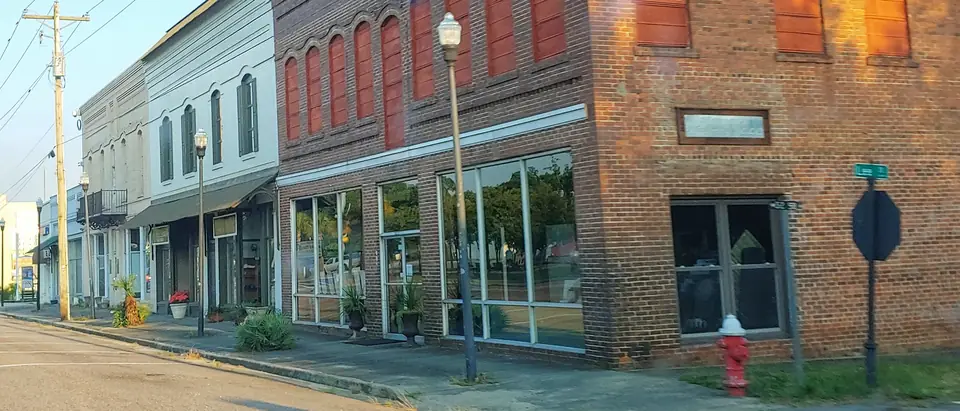 A row of historic brick storefronts on Main Street in downtown Wagener, SC, in warm evening light