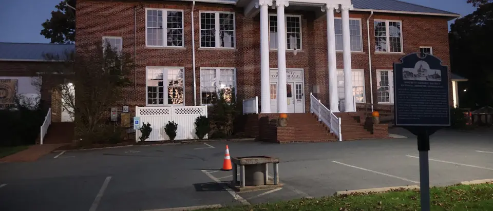 The red-brick, white-columned Whitsett Town Hall at dusk in Whitsett, NC