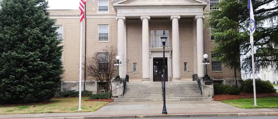 The white-columned York County Courthouse with flags and evergreens in downtown York, SC